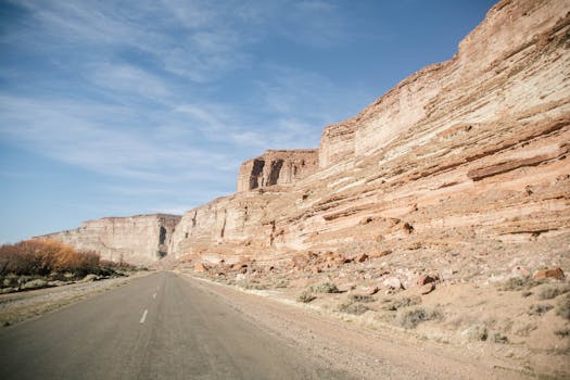 Vast desert landscape with rock formations and open road in Paso de Indios, Argentina.