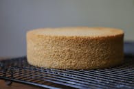 一块普通的海绵蛋糕正在铁丝架上冷却，准备装饰或食用