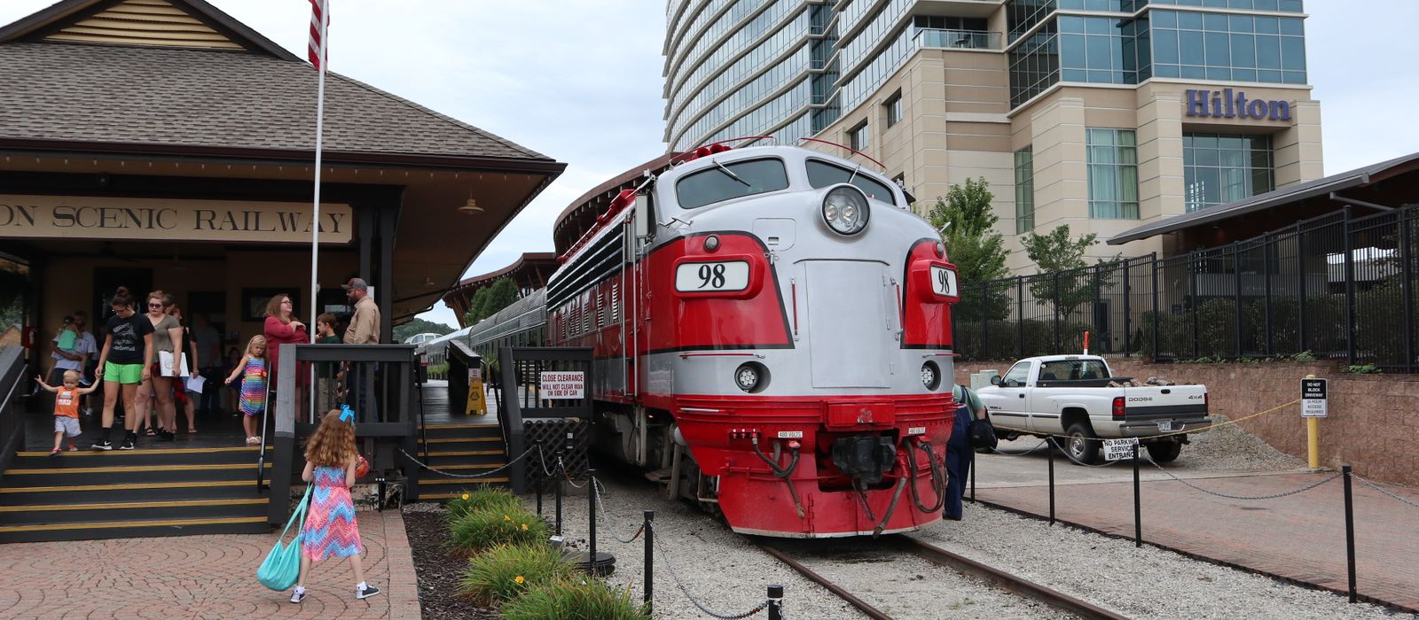 A classic locomotive at Branson Scenic Railway station with tourists in Missouri.