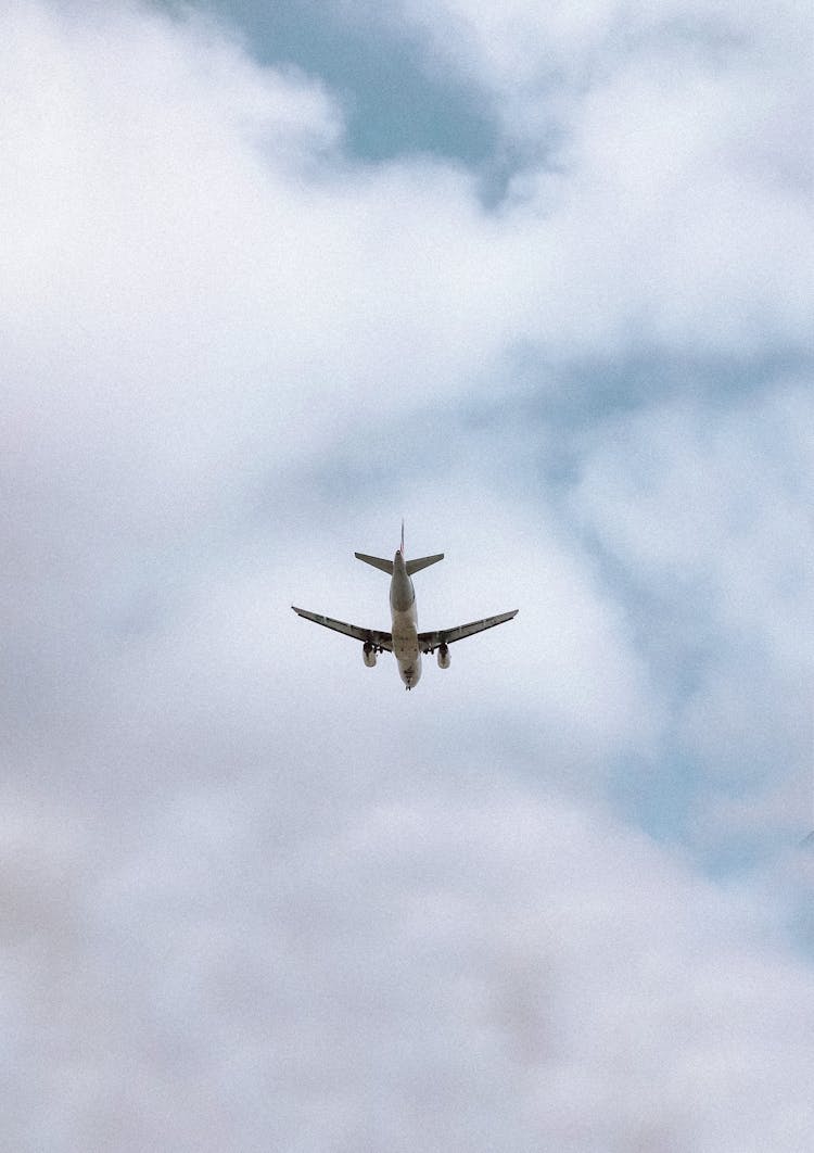 White Airplane Flying In The Cloudy Sky