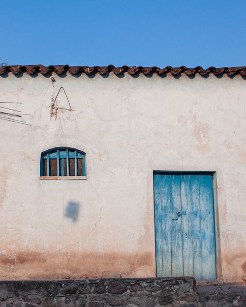 Blue Wooden Door and Window on Concrete Wall