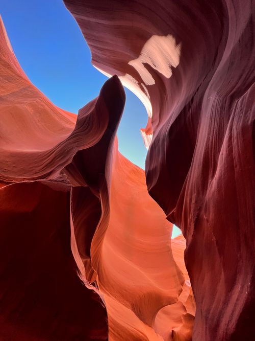 Free Stunning view of Antelope Canyon's sandstone curves under a clear blue sky. Stock Photo