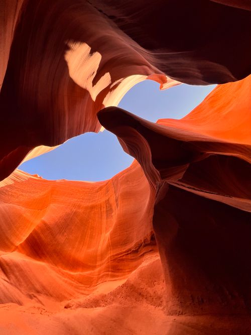Free Breathtaking view of Lower Antelope Canyon with vibrant rock formations and clear blue sky. Stock Photo