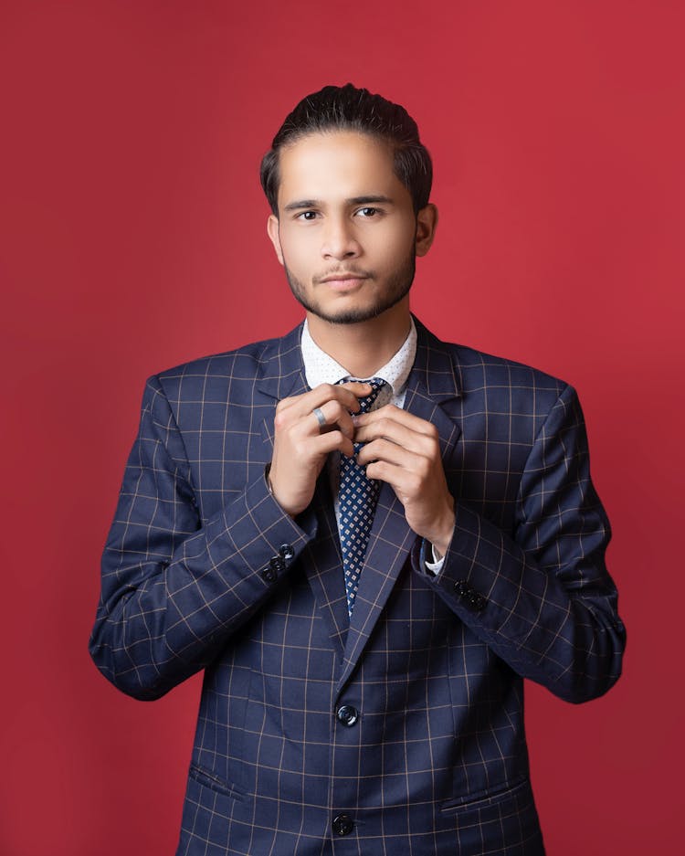 Close-Up Shot Of A Man Wearing Blue Plaid Suit On Red Background