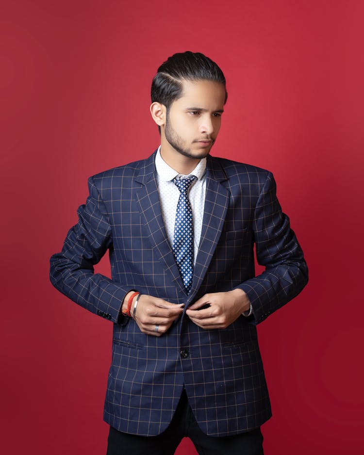 Close-Up Shot Of A Man Wearing Blue Plaid Suit On Red Background