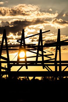 A striking silhouette of industrial structures against a dramatic sunset sky.