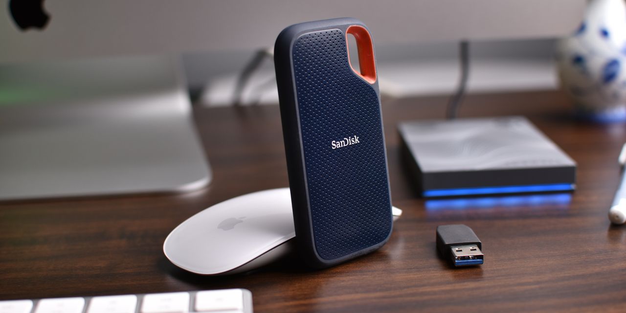 Close-up of a desk setup featuring external hard drives, mouse, and USB stick.