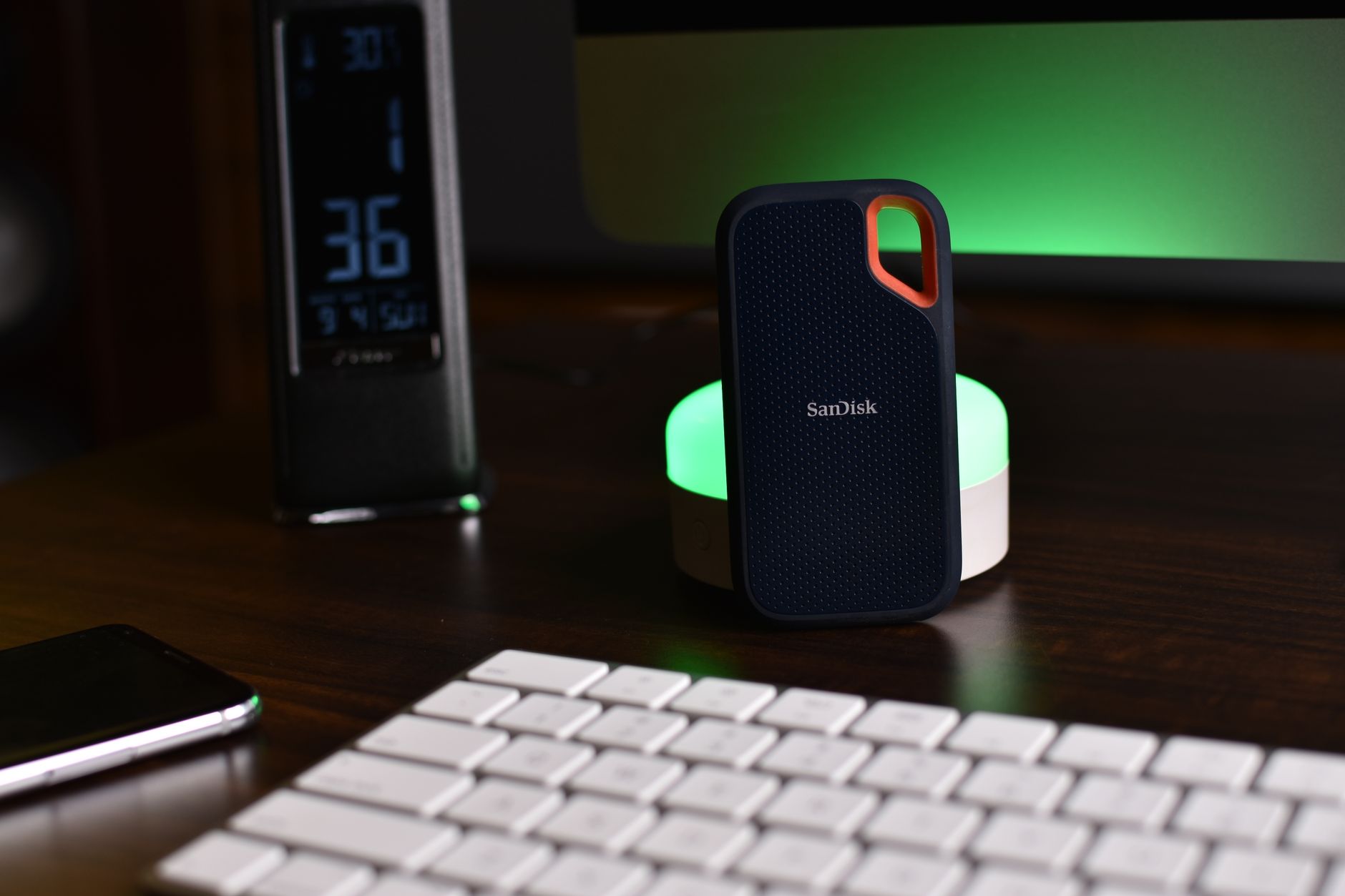 Synology NAS device on a desk with home office setup glowing LED