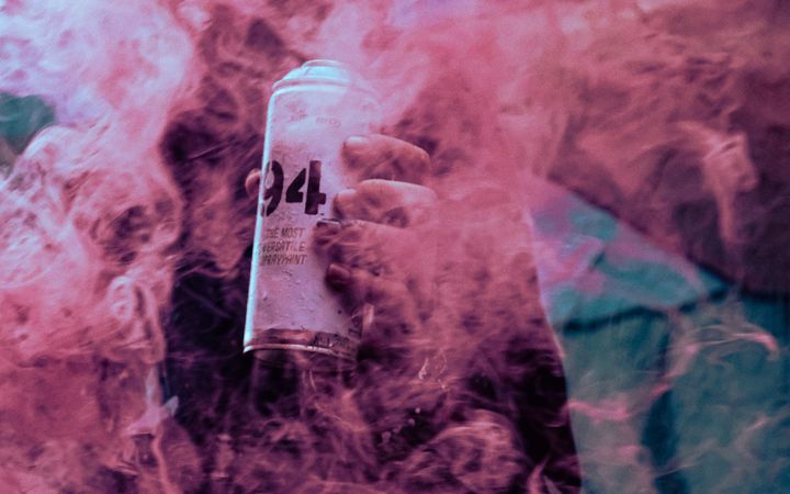 Colorful photo of street art with spray paint and pink smoke, Bogotá.