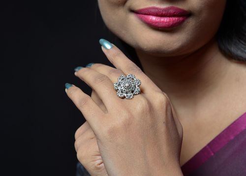 Free Elegant close-up of a woman displaying a silver floral ring. Stock Photo