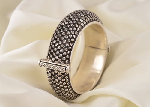 Close-Up Shot of a Silver Ring on White Textile