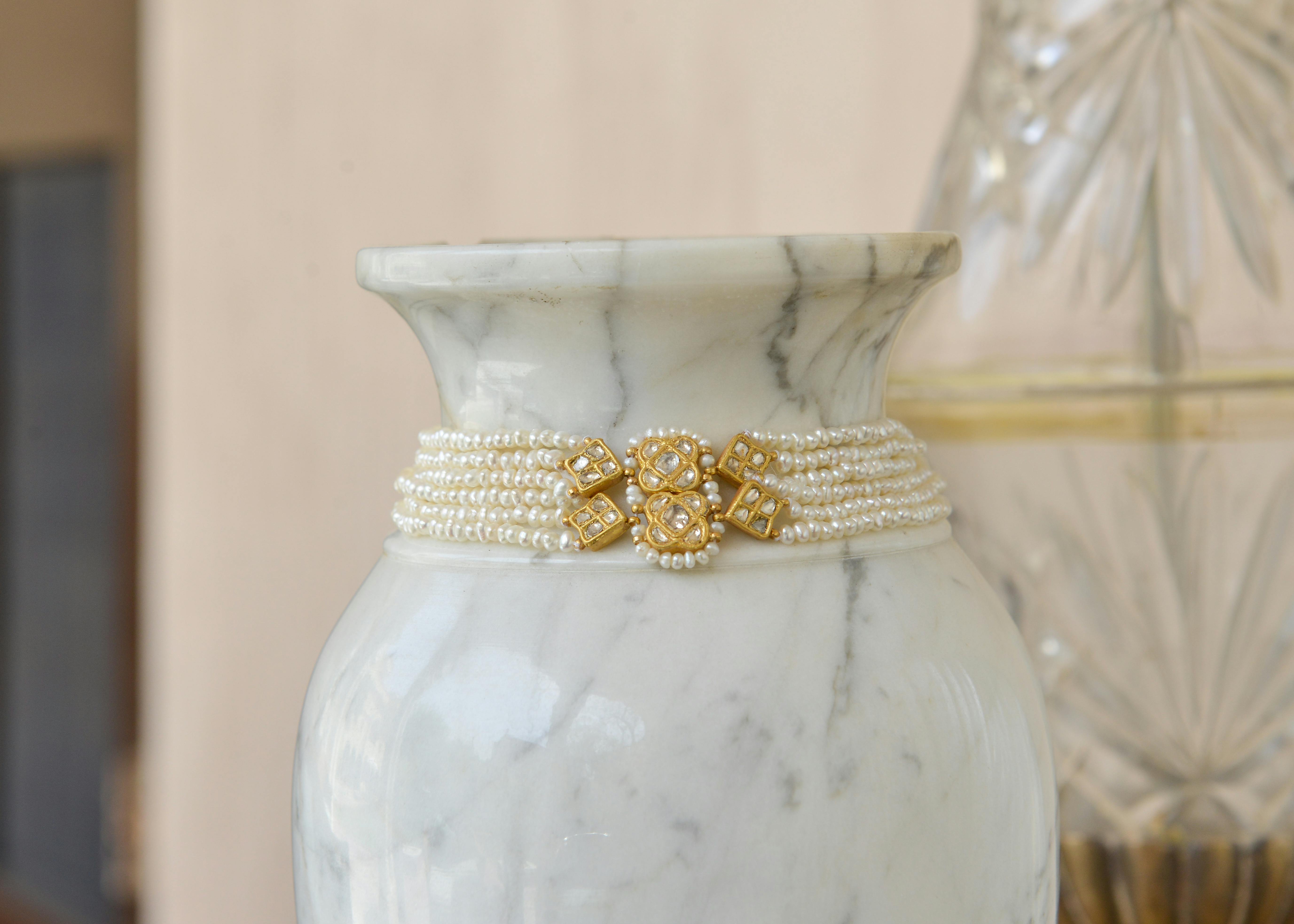 gold and white jewelry on white and gray ceramic vase