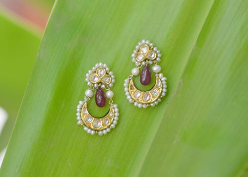 A Pair of Pearl Earrings on Green Leaf