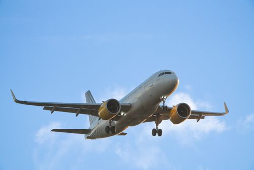 Free Low angle view of a commercial airplane flying against a clear blue sky in O Seixo, Spain. Stock Photo