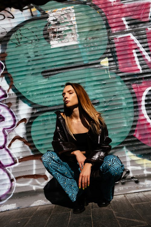 Woman in Black Leather Jacket and Blue Pants
