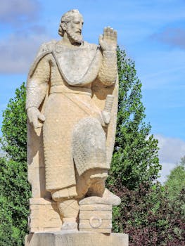 Stone statue of Martin Antolinez in Burgos, Spain under clear sky, showcasing historical artistry.