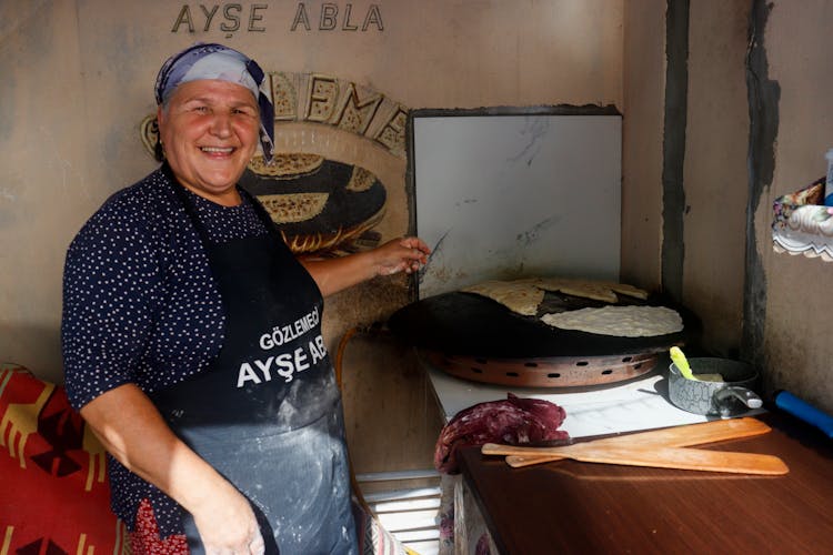 Happy Elderly Woman Cooking Traditional Food 