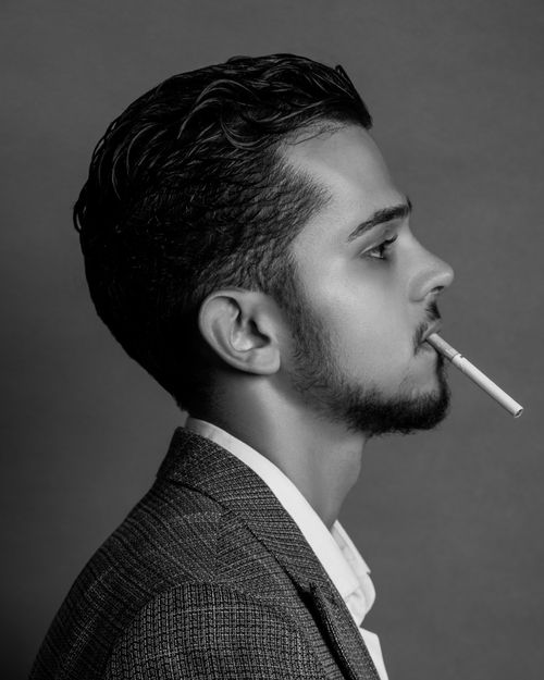Free Black and white side profile of a man smoking a cigarette, exuding a classic and moody atmosphere. Stock Photo