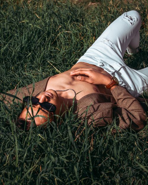 Free Man resting on grass wearing sunglasses and an open shirt in Tehran, Iran. Stock Photo