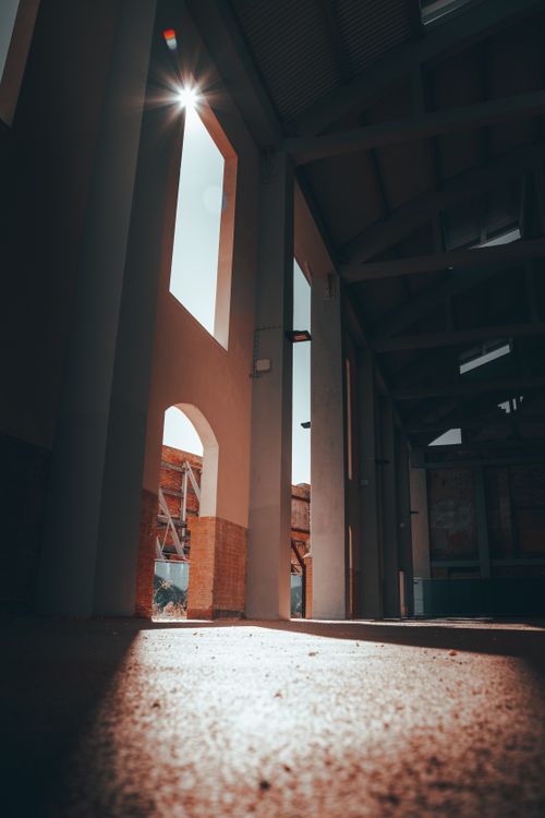 Free Sunlight streaming through industrial arches in Venice, Italy, creating dramatic shadows. Stock Photo