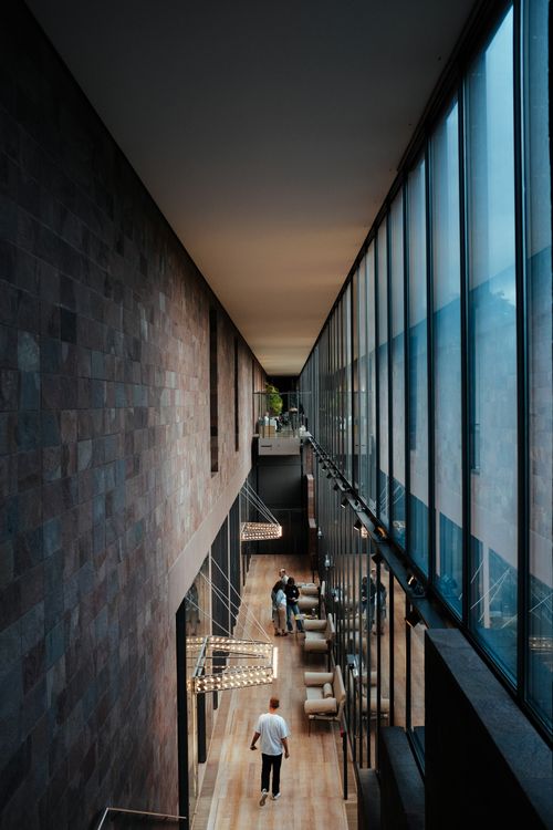 Free A spacious corridor featuring modern architecture with glass walls and ceiling lights. Stock Photo