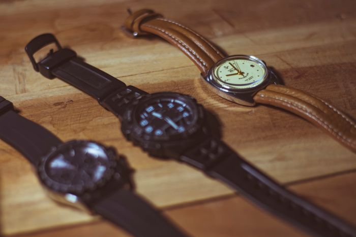 Three analogue wristwatches laid out on a wooden bench for comparison — photo by Ranjit Pradhan on Pexels
