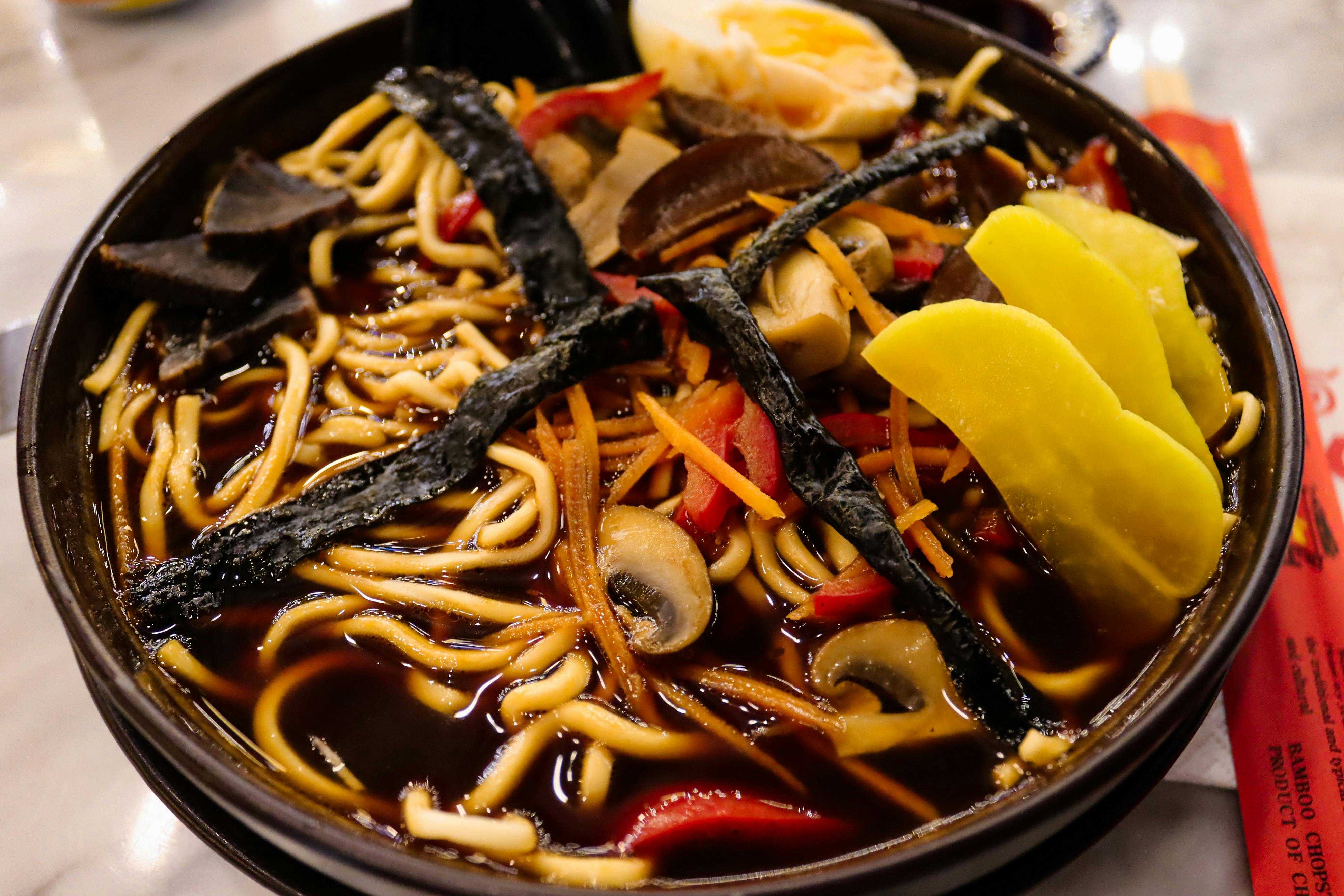 Close-up of a flavorful ramen noodle bowl with diverse toppings including mushrooms and eggs.
