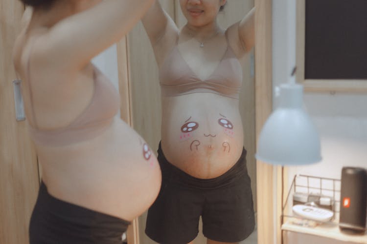 Pregnant Woman With Art Painting On Her Belly