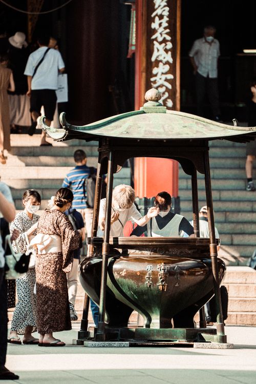 Free Candid capture of people at a temple cauldron, showcasing cultural interactions. Stock Photo