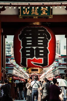 Iconic Sensoji Temple entrance in Tokyo, bustling with tourists under the giant red lantern.