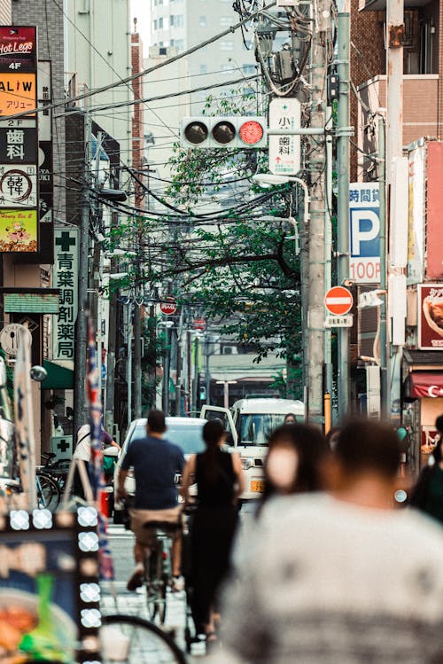 People Walking on a Busy Street with Traffic Light