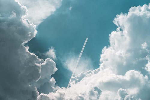 A Jet Plane Under the Blue Sky and White Clouds