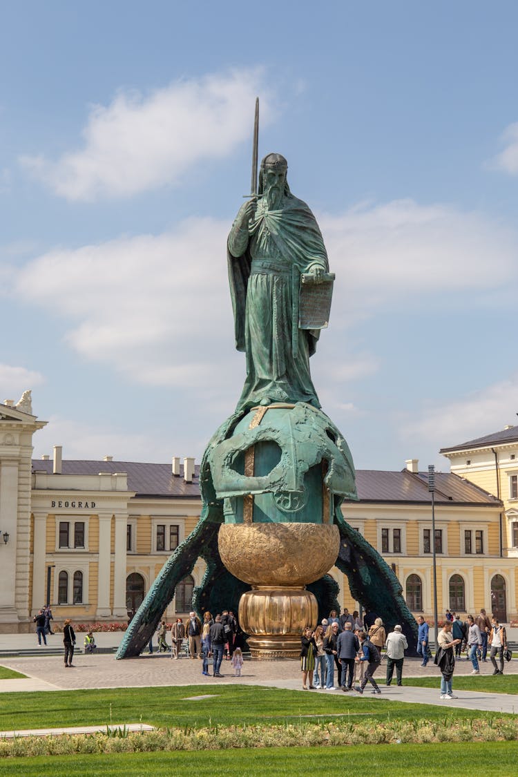 Green Statue Of Man Holding A Sword