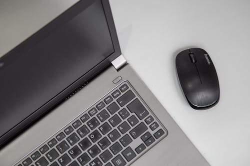 High Angle Shot of a Laptop and Wireless Mouse