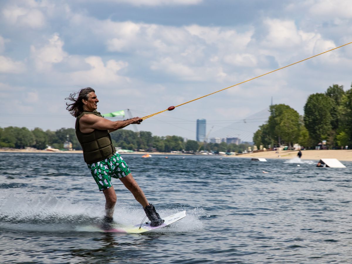 Wakeboarder riding across a sunny lake