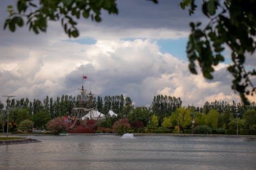 A Brown Ship on Body of Water Under Cloudy Sky