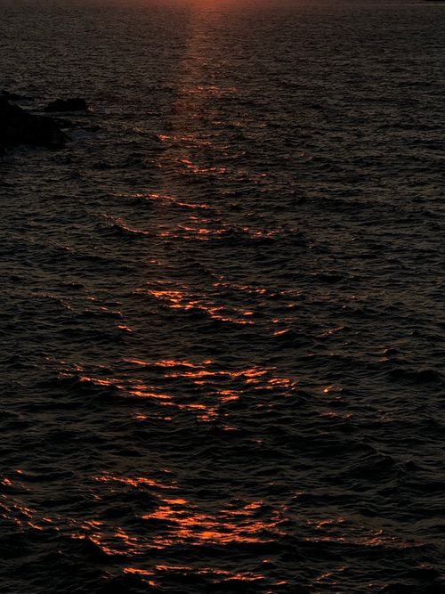 Free A captivating view of the sunset reflecting over the Aegean Sea near Milos, Greece, with dark tranquil waters. Stock Photo
