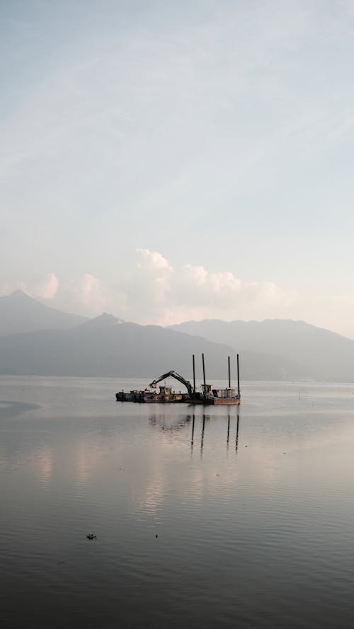A Boat on Body of Water with Crane 