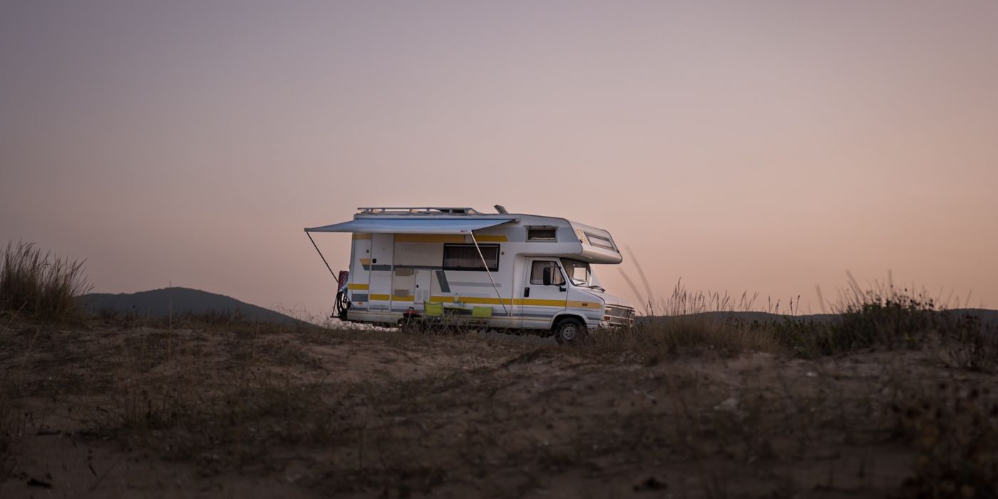 Class A motorhome parked at a campsite at sunset