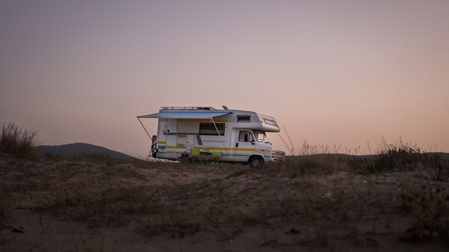 Class A motorhome parked at a campsite at sunset