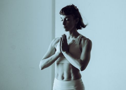 A serene woman meditating and practicing yoga indoors, conveys calm and mindfulness.