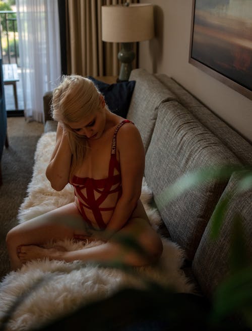 A Woman in Red Lingerie Sitting on the Couch