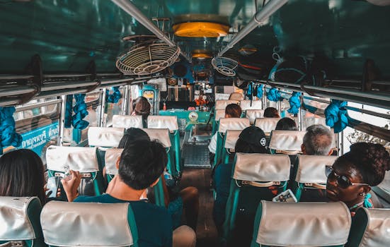 A diverse group of tourists traveling on a bus in Kanchanaburi, Thailand.