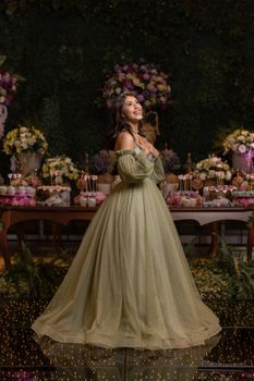 Glamorous quinceañera celebration featuring a smiling teenager in a stunning green ball gown.