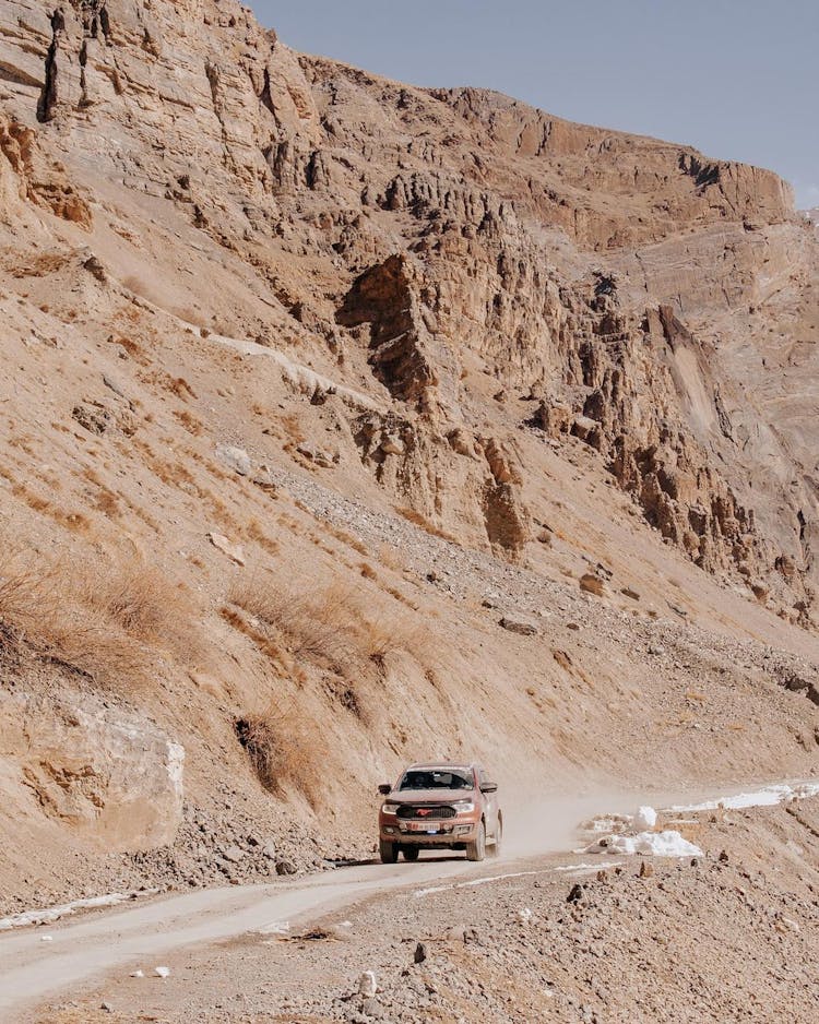 A Car On The Road Near The Rocky Mountain