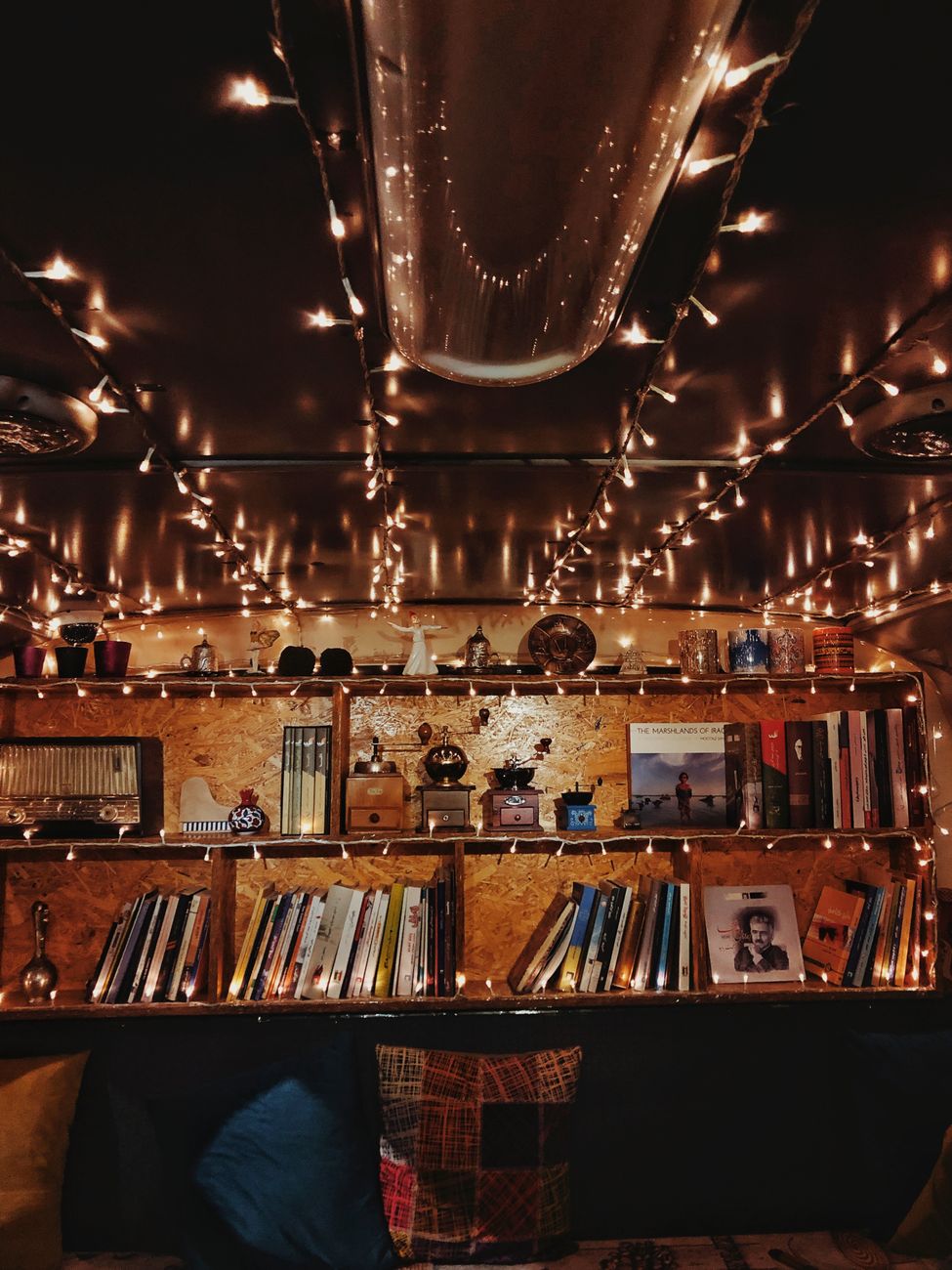 A warm, vintage-inspired bookshelf setup with string lights, evoking a nostalgic and cozy atmosphere.