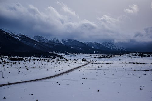 Snow Covered Mountains Under White Cloudy Sky