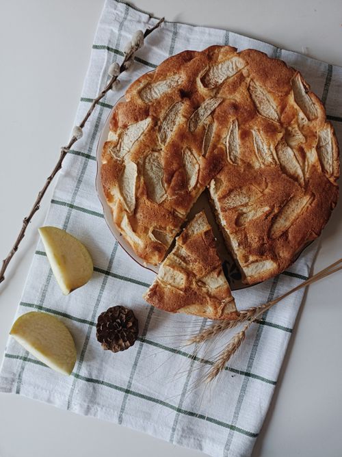 Free A mouthwatering apple pie with a slice removed, resting on a stylish checkered cloth. Stock Photo