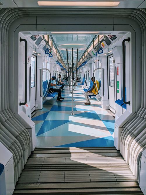Free Bright and airy train interior with seated passengers, showcasing modern urban transportation design. Stock Photo
