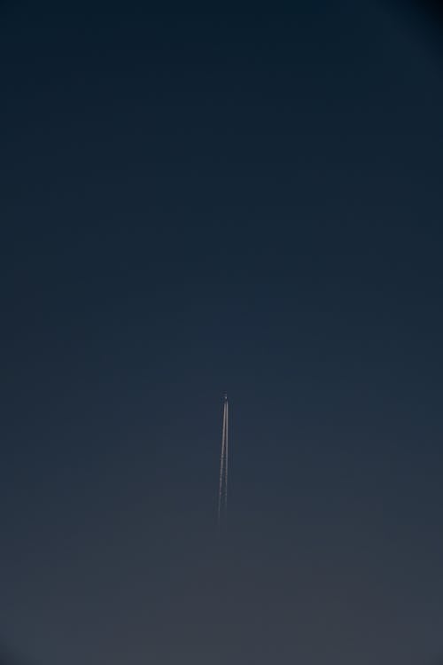 Airplane and Its Trail Far Up in the Sky 